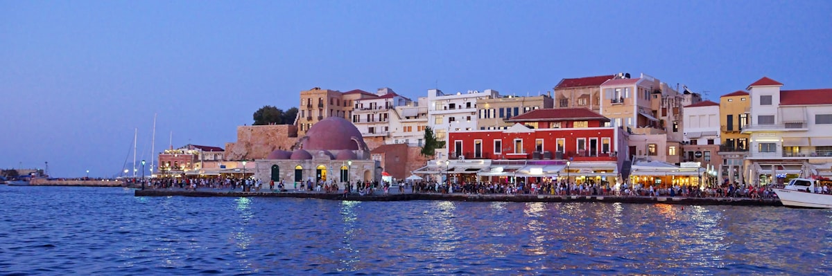 Colourful Venetian buildings reflected in the harbour water of Chania old town Crete at evening