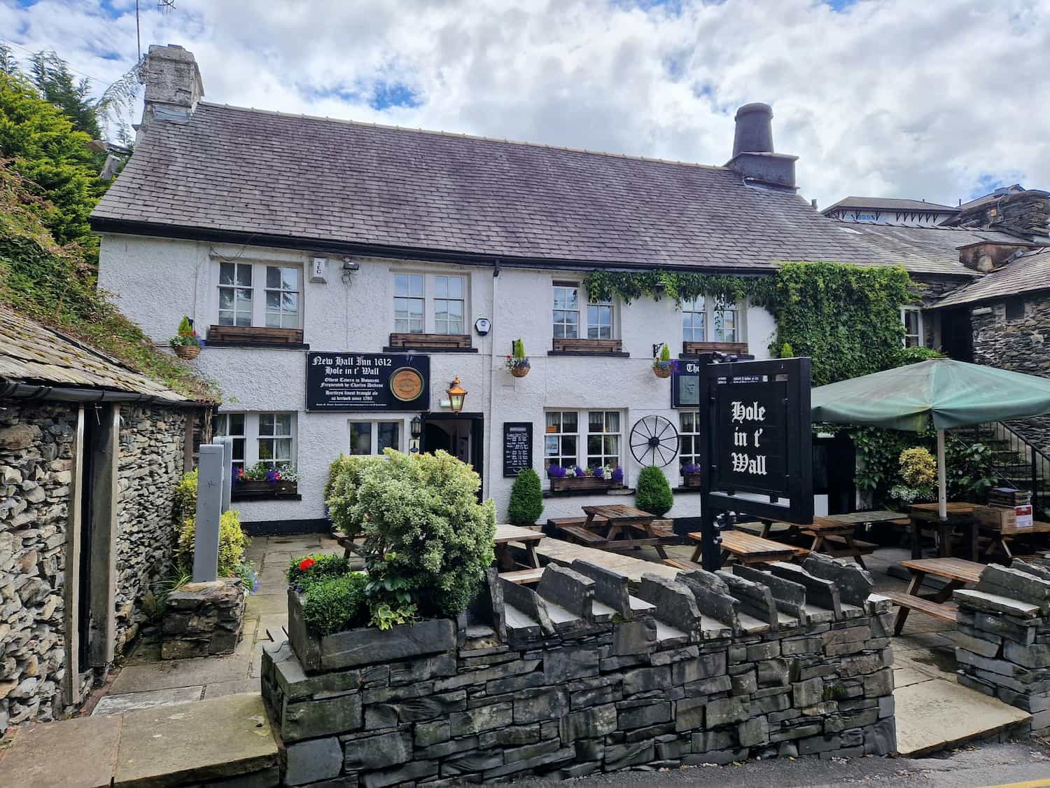 A traditional English country pub with stone walls and hanging flower baskets