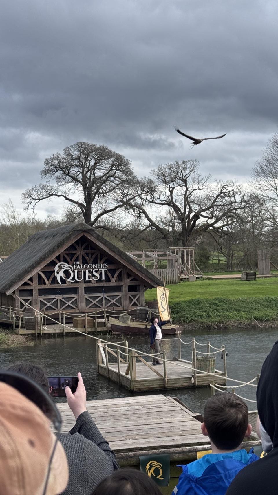 A bird of prey in flight above the Falconer's Quest arena at Warwick Castle riverside